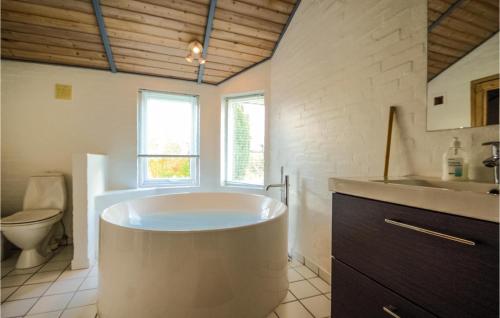 y baño con bañera, aseo y lavamanos. en Amazing Home In Hejls With 3 Bedrooms, Sauna And Wifi, en Hejls
