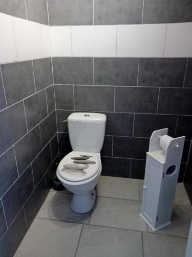 a bathroom with a toilet in a tiled wall at la pêcherie bord de mer in La Plaine-sur-Mer