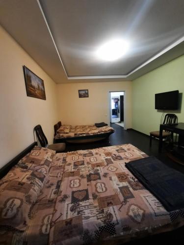 a room with a bed and a tv in it at Шикарная 2к квартира Центральный парк Университет 70м in Irpin'