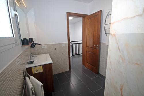 a bathroom with a sink and a wooden door at Villa Can Bella, 350m zum Strand in Cala Galdana