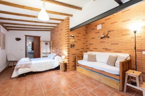 2 camas en una habitación con una pared de ladrillo en Apartamentos Econatur en Rubiales