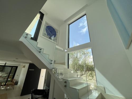 Una escalera en una casa con una gran ventana en Preciosa Villa en Siesta en Santa Eulalia del Río