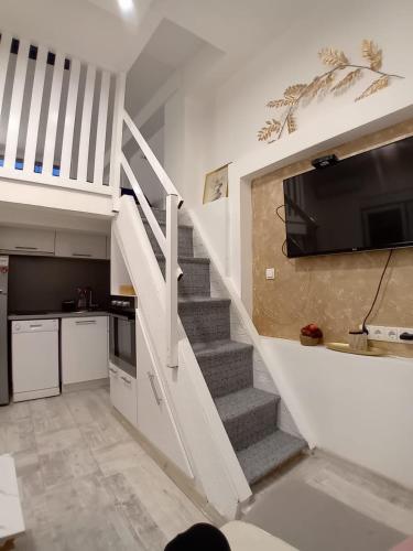 a living room with a staircase with a flat screen tv at Maksumic Apartman in Mostar