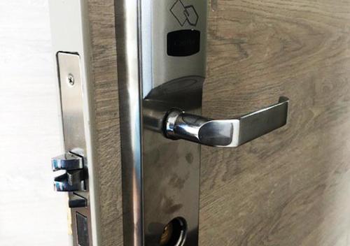 a metal door with a handle on a wooden door at Hotel Suites La Fontana in Ambato