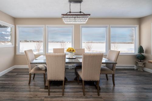 a dining room with a table and chairs and windows at Gallatin Gateway Getaway in Bozeman
