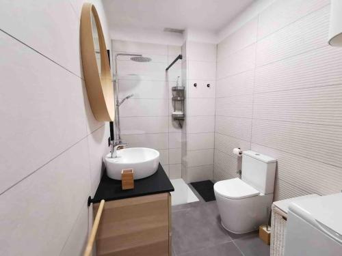 a white bathroom with a sink and a toilet at Apartamento en Los Acantilados de los Gigantes in Acantilado de los Gigantes