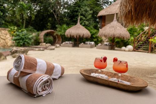 - une serviette et deux verres de cocktails sur une table dans l'établissement Oom Bubble Boutique Riviera Cancun, à Puerto Morelos