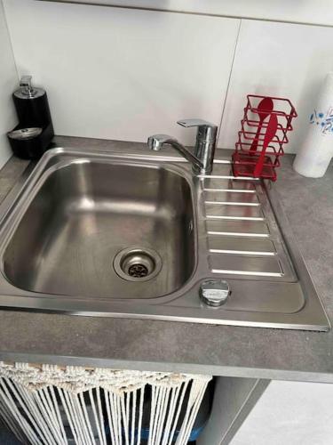 - un évier de cuisine avec un soudeur rouge à côté dans l'établissement Mini house jaccuzi campagne proche mer&lac, à Flayosc