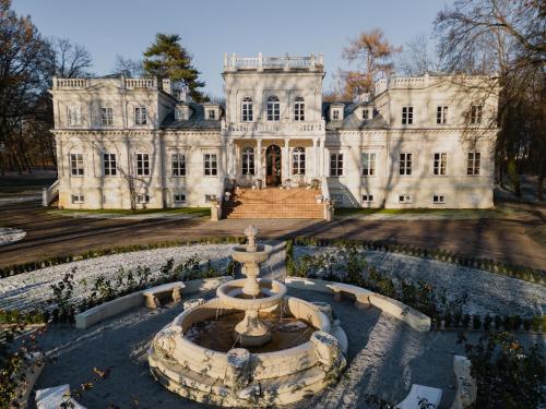 an old mansion with a fountain in front of it at Pałac Chojnata in Wola Chojnata