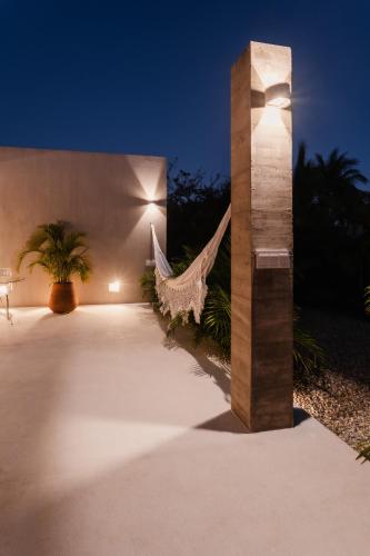 a hammock in front of a building at night at Casa SANA - Healthy Lifestyle Luxury Villa in Puerto Escondido