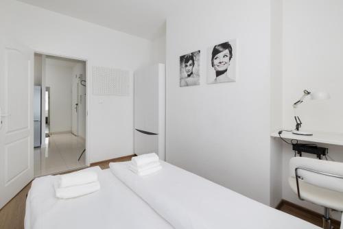 um quarto branco com uma cama e um lavatório em Rynek Sienny Cosy Apartment em Szczecin