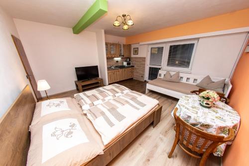 a bedroom with two beds and a table in it at PENZION NA VÝSLUNÍ in Nové Město nad Metují