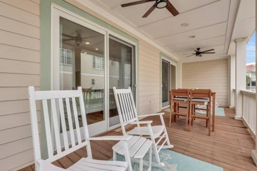 a porch with two white chairs and a table at 5 Bed 5 Bath Luxury Beach Front Home w/Ocean Views in Tybee Island