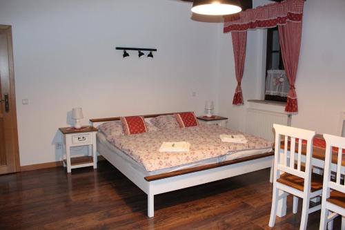 um quarto com uma cama com 2 cadeiras e uma janela em Penzion Za plotem 