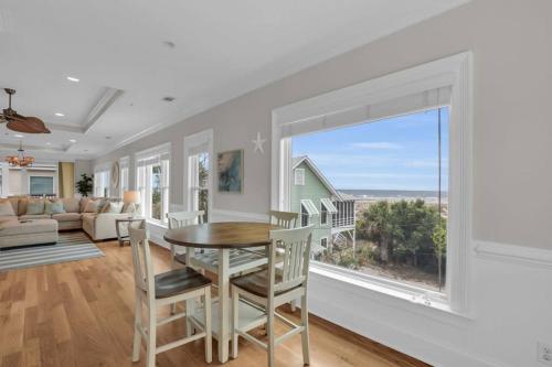 a dining room with a table and chairs and a large window at 5 Bed 5 Bath Luxury Beach Front Home w/Ocean Views in Tybee Island