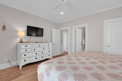 a white bedroom with a bed and a tv at 5 Bed 5 Bath Luxury Beach Front Home w/Ocean Views in Tybee Island