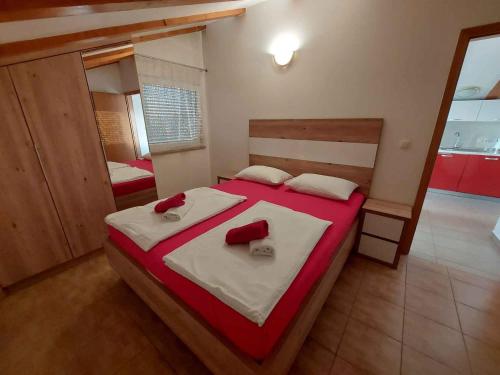 een slaapkamer met een groot bed met rode en witte lakens bij Apartment Ljubac 3 in Ljubač