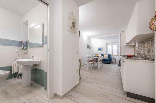 a white bathroom with a sink and a kitchen at Apartment in Cala Gonone - Nuoro (Provinz) 48226 in Cala Gonone
