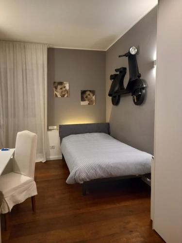 a small bedroom with a bed and a chair at Maison B - Locazione turistica in Brugherio