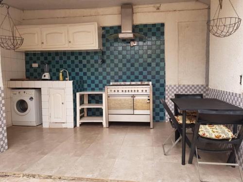 a kitchen with a stove and a table in it at La Résidence in Lomé