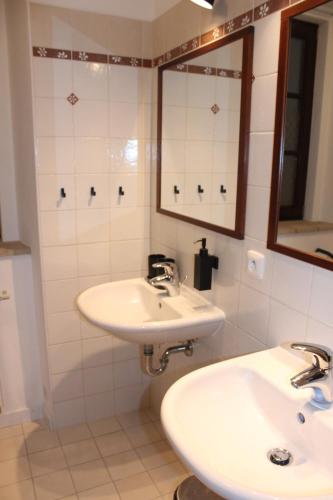 uma casa de banho com 2 lavatórios e um espelho em Penzion Za plotem 