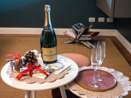 a bottle of wine on a table with a glass at L'Americano Luxury Rooms in Chiavari