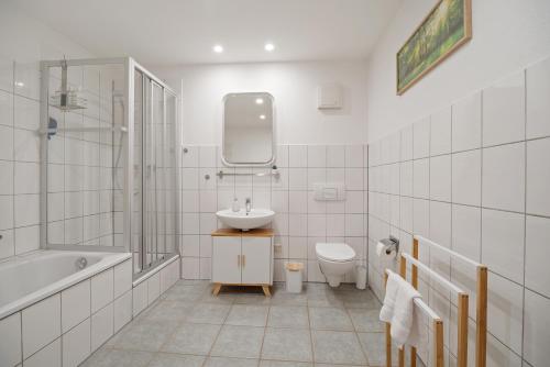 a bathroom with a sink and a toilet and a bath tub at City Center Maisonette Apartment für 8 Personen in Weimar