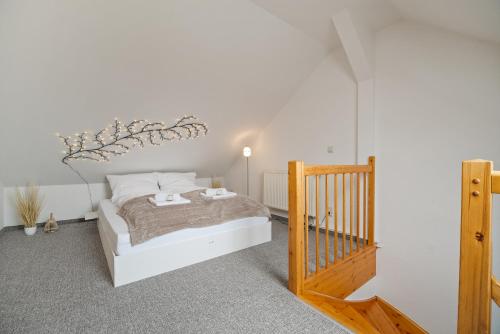 a bedroom with a white bed and a staircase at City Center Maisonette Apartment für 8 Personen in Weimar