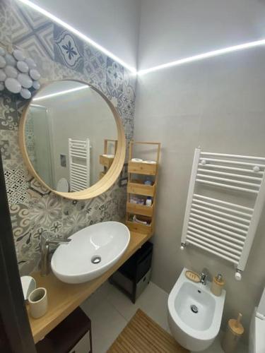 a bathroom with a sink and a mirror and a toilet at Vatican Paradise Pisana 43 in Rome