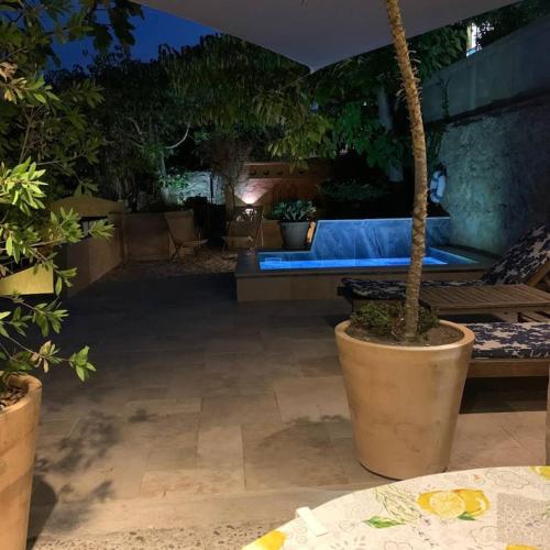- un patio la nuit avec un banc et des plantes en pot dans l'établissement Maisonnette indépendante, à Cassis