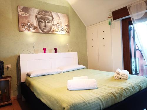 1 dormitorio con 1 cama con 2 toallas en La Mansarda di Pero con terrazza, en Pero