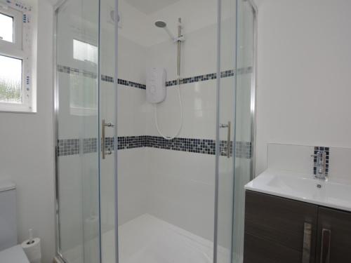 y baño con ducha y lavamanos. en 3 bed property in Ferryside 53442, en Ferryside