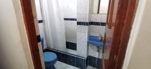 uma casa de banho com um WC azul e um lavatório. em HOSTAL EL REFUGIO em Huanchaco