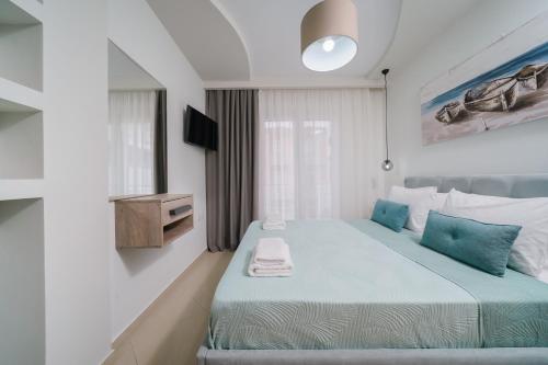 a bedroom with a large bed with blue pillows at Tarsa's House by the Sea in Skala Marion