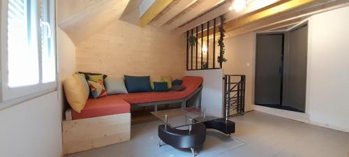 sala de estar con sofá rojo y mesa de cristal en Lamatacam 9.1 Armoise Duplex 2 chambres en Argelès-Gazost
