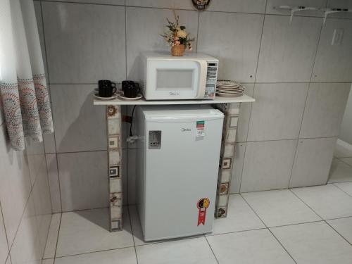een magnetron bovenop een koelkast in een keuken bij Apartamento Aconchego 102 in Paulista