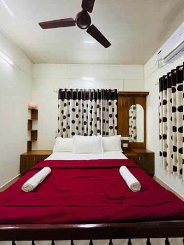 a bedroom with a large red bed with a ceiling fan at Eden cabana in Alleppey