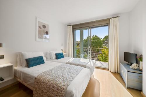 a bedroom with a bed and a large window at Duplex Can Volanti in Port de Pollensa