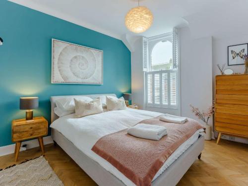 sypialnia z dużym łóżkiem z niebieską ścianą w obiekcie 2 bed property in Rye 87139 w mieście Rye