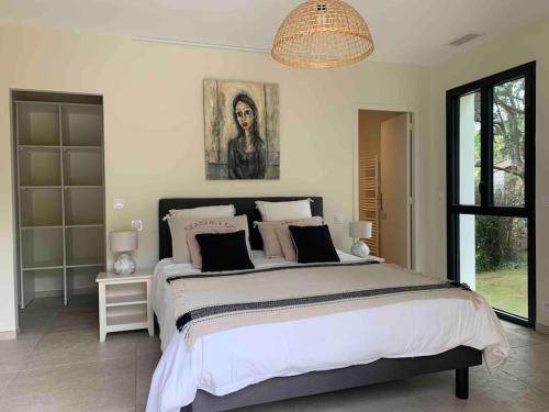 une chambre avec un grand lit et un lustre dans l'établissement Villa proche océan et golf, à Anglet