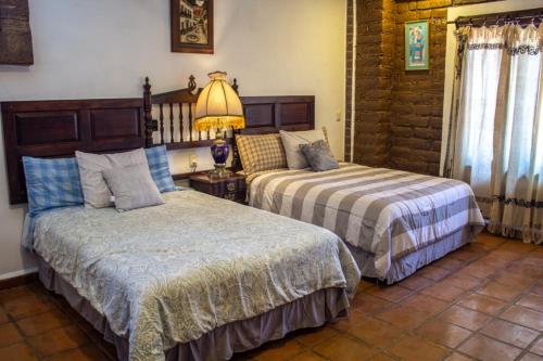 a bedroom with two beds and a lamp at Solache Inn in Zitácuaro