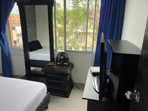 Schlafzimmer mit einem Bett, einem Spiegel und einem Schreibtisch in der Unterkunft Casa de lujo muy amplía con ubicación privilegiada in Medellín