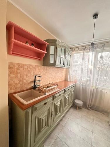 a kitchen with a sink and a window at Cozy apartment in Galati in Galaţi