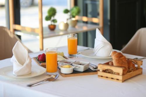 a table topped with plates of food and orange juice at Blue Bay Residence in Vlorë
