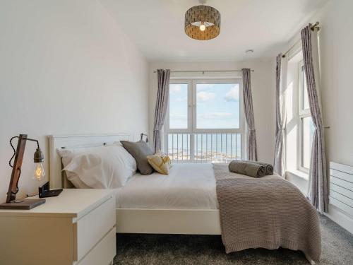 een slaapkamer met een bed en een groot raam bij 4 Bed in Whitley Bay 87396 in Whitley Bay