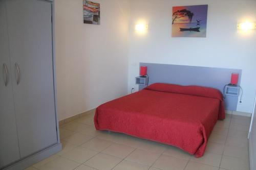 - une chambre avec un lit rouge et une couverture rouge dans l'établissement RESIDENCE ELLADA 2 PISCINE PLAGE VUE MER, à Cargèse