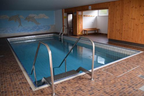 a large swimming pool in a building with at Appartement Bergfrieden in Oberstaufen