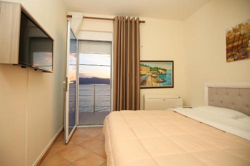 a bedroom with a bed and a view of the ocean at Blue Bay Residence in Vlorë