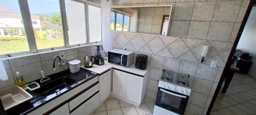eine kleine Küche mit einer Spüle und einem Herd in der Unterkunft Apartamento 102 mobiliado 2 quartos Jaraguá do Sul-SC in Jaraguá do Sul
