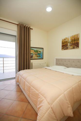 a bedroom with a large bed and a window at Blue Bay Residence in Vlorë